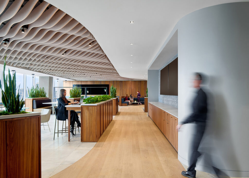 Open workplace corridor with wood cabinetry and collaborative seating.