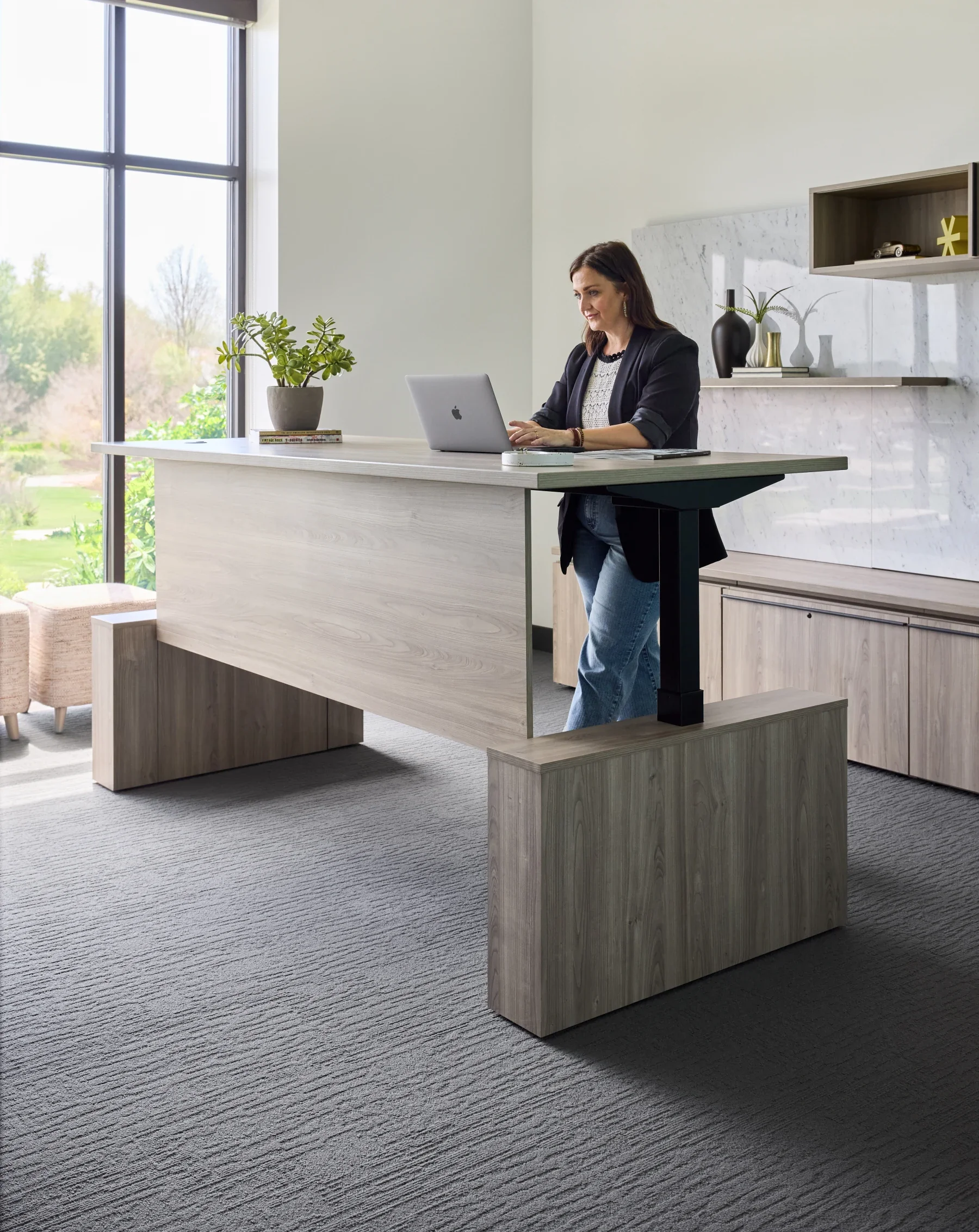 Height-adjustable private-office desk and integrated storage.