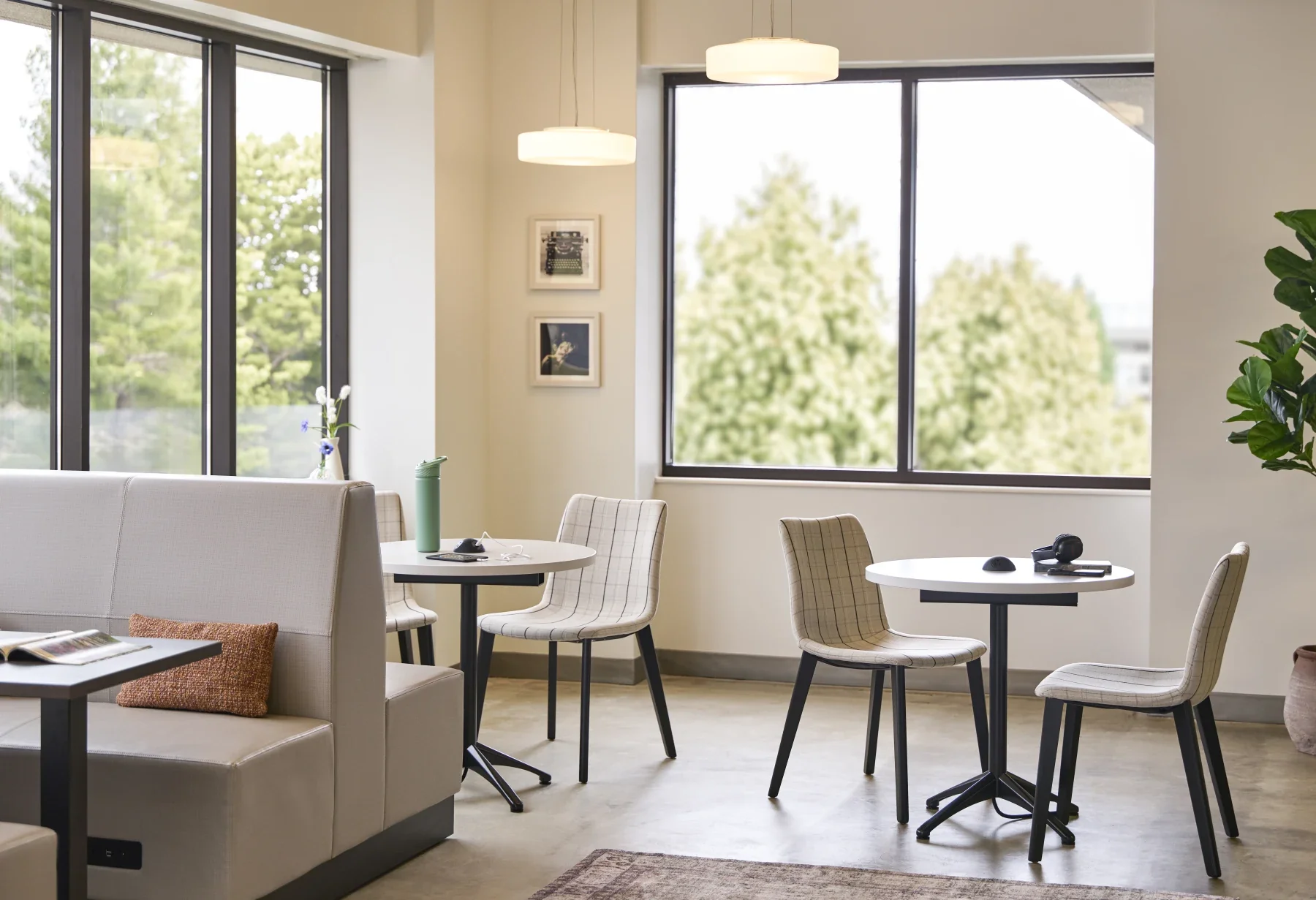 Flexible café-height tables and seating beside large windows.