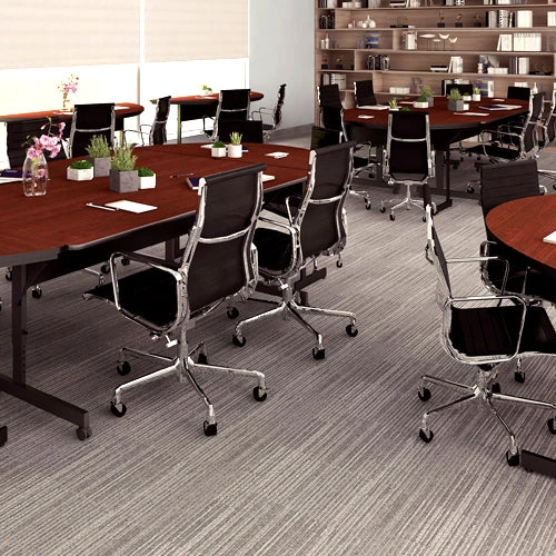Commercial training and meeting area with tables and black chairs in a bright interior