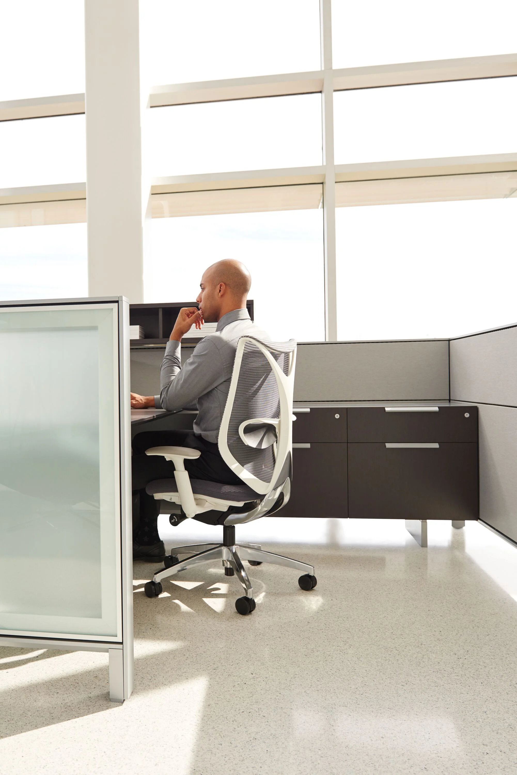 Employee working at a Teknion District workstation with integrated storage.