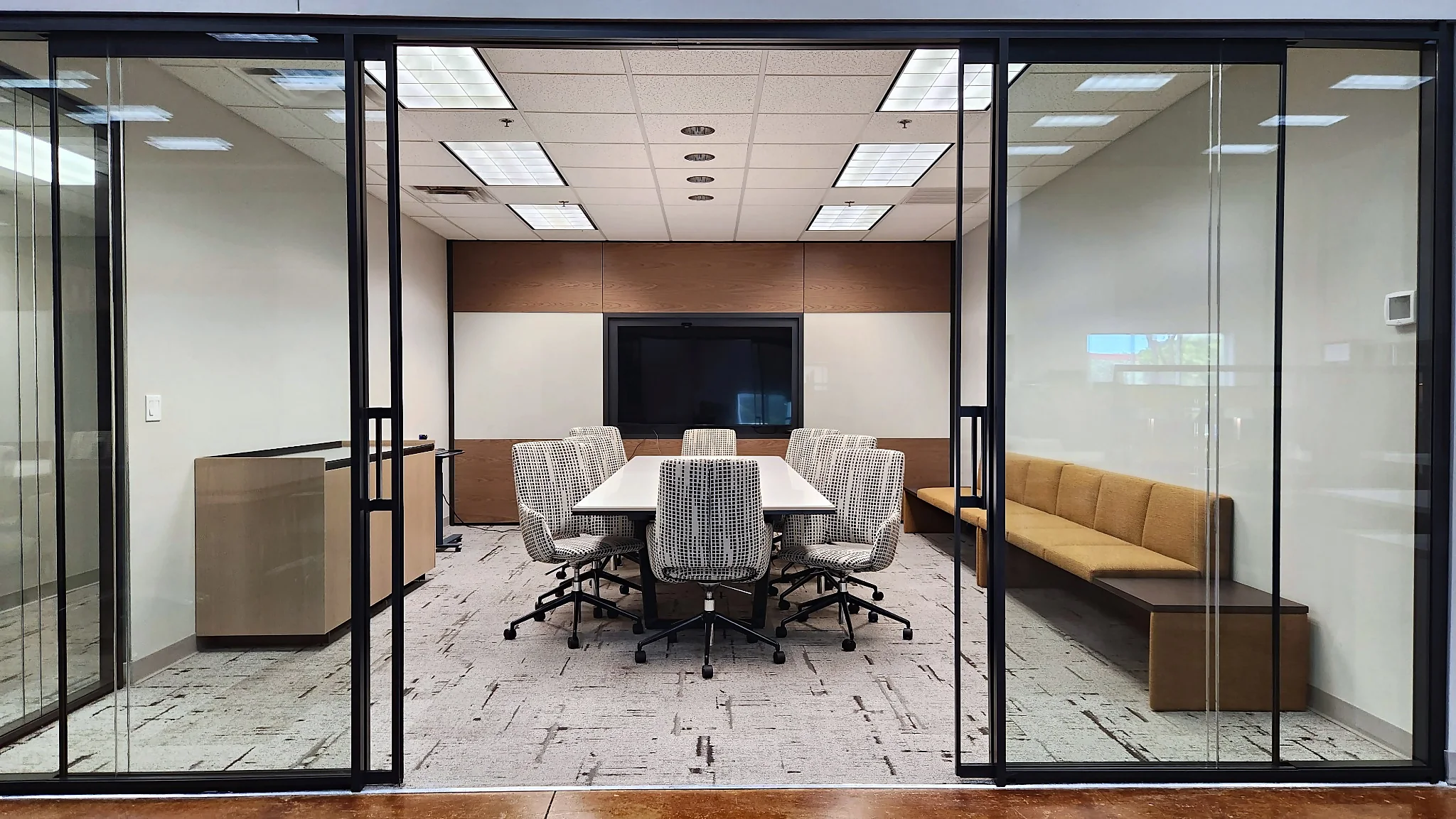 Glass-enclosed conference room with a meeting table and seating in the Pettus Interiors Little Rock showroom