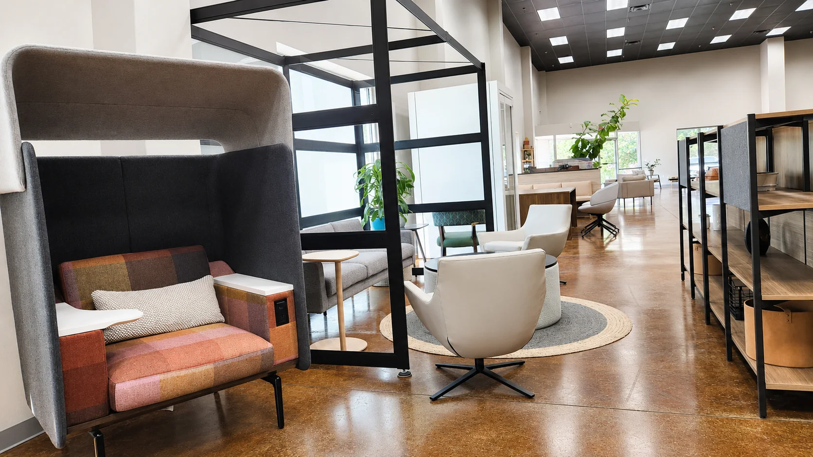 Lounge seating vignette beside glass office walls in the Pettus Interiors Little Rock showroom