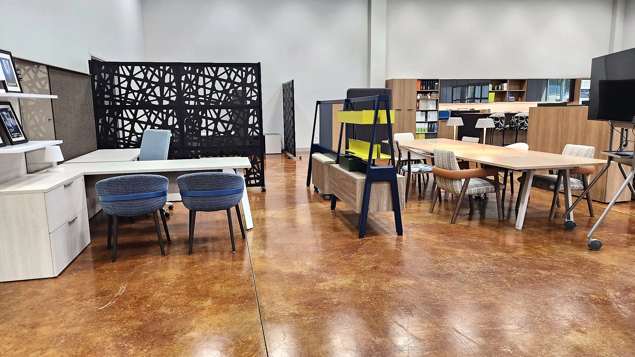 Open collaboration area with tables, seating, and workstations in the Pettus Interiors Little Rock showroom