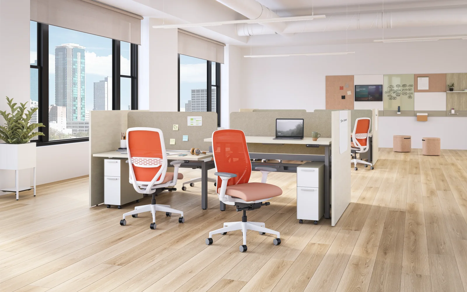 HON open office with low-panel workstations and red and pale-pink mesh-backed task chairs on a light wood floor