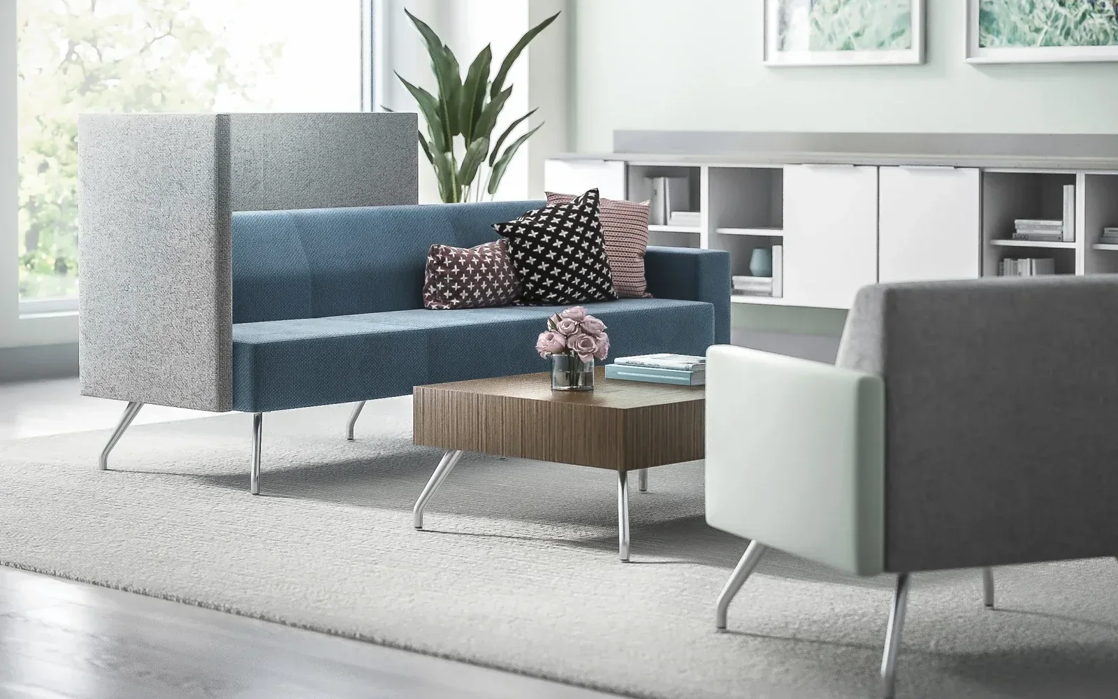 Interwoven Pairings Health seating area with blue and gray high-back lounge pieces around a wood coffee table