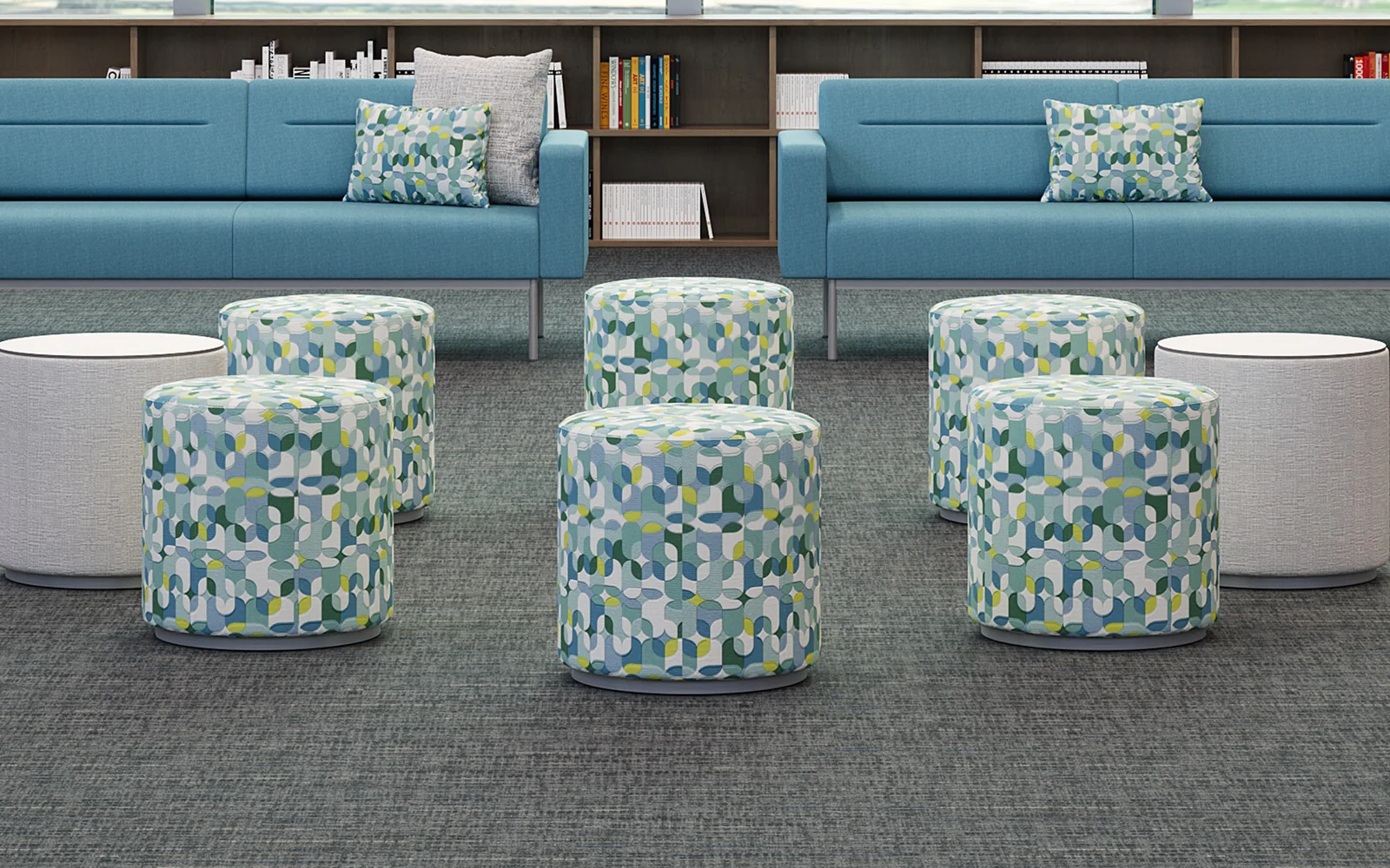 Blue high-back Lesro sofas with patterned cylindrical ottomans and white round tables in a library lounge